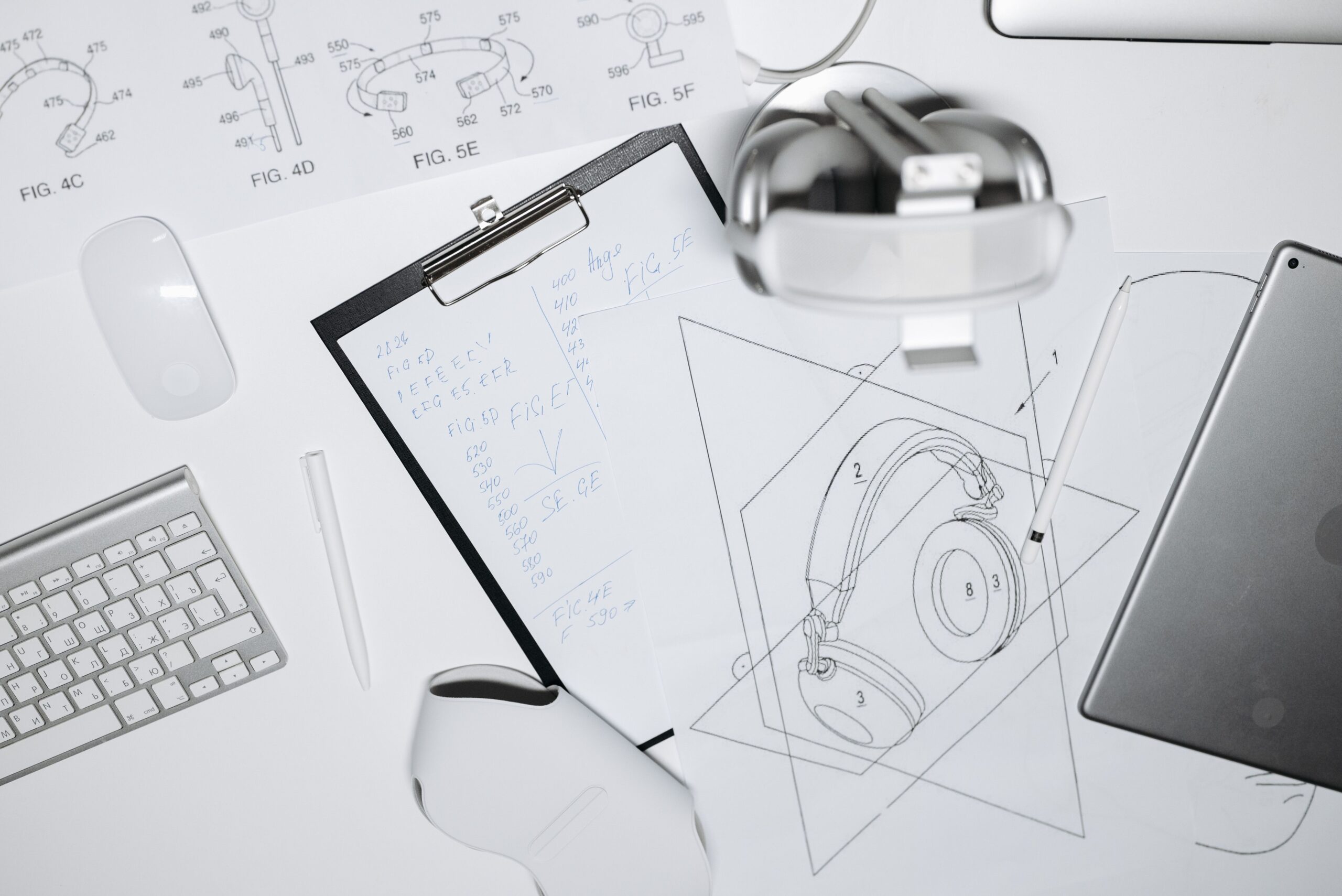 Headphones, product design sketches and technical drawings on a desk